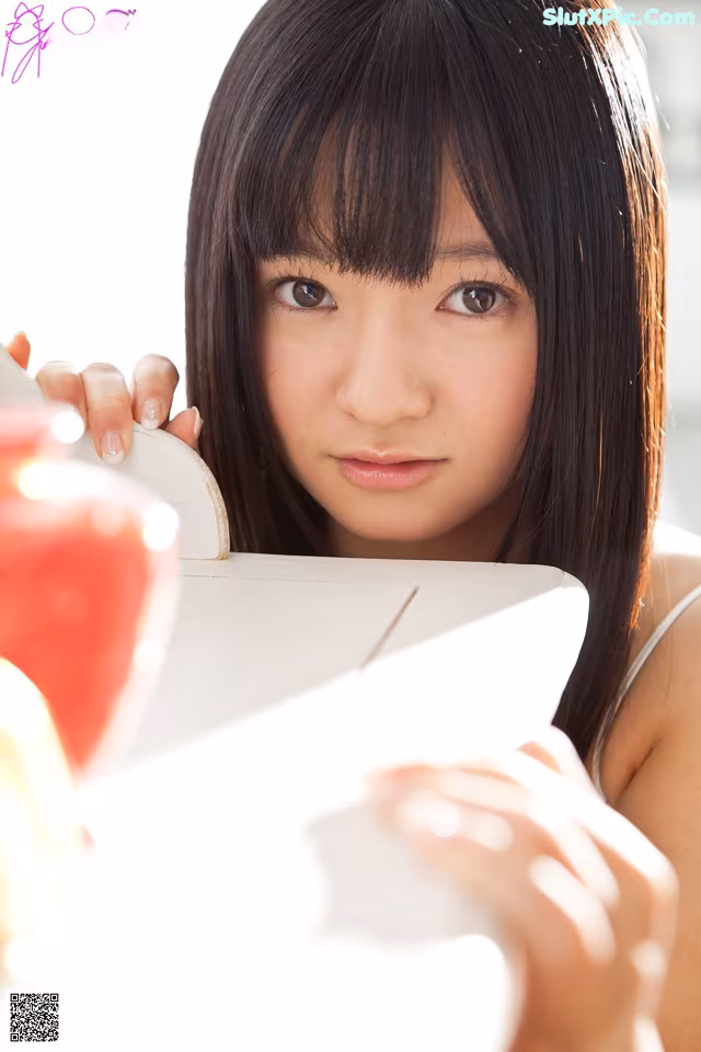 A young woman holding a box of food in her hands.