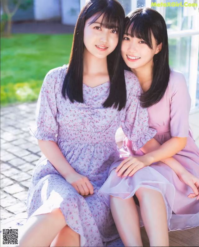 A couple of young women sitting next to each other.