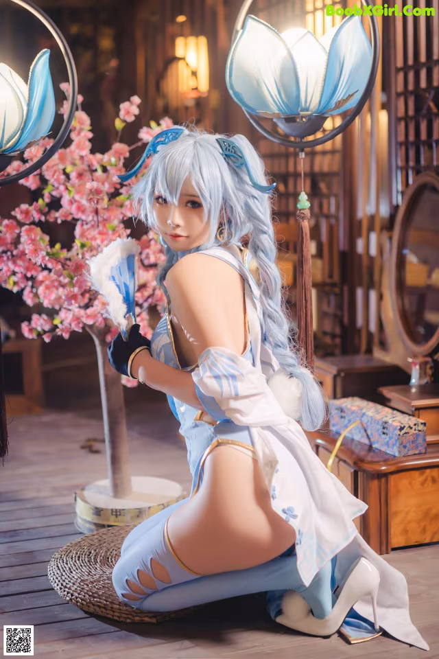 A woman in a blue and white outfit sitting on the floor.