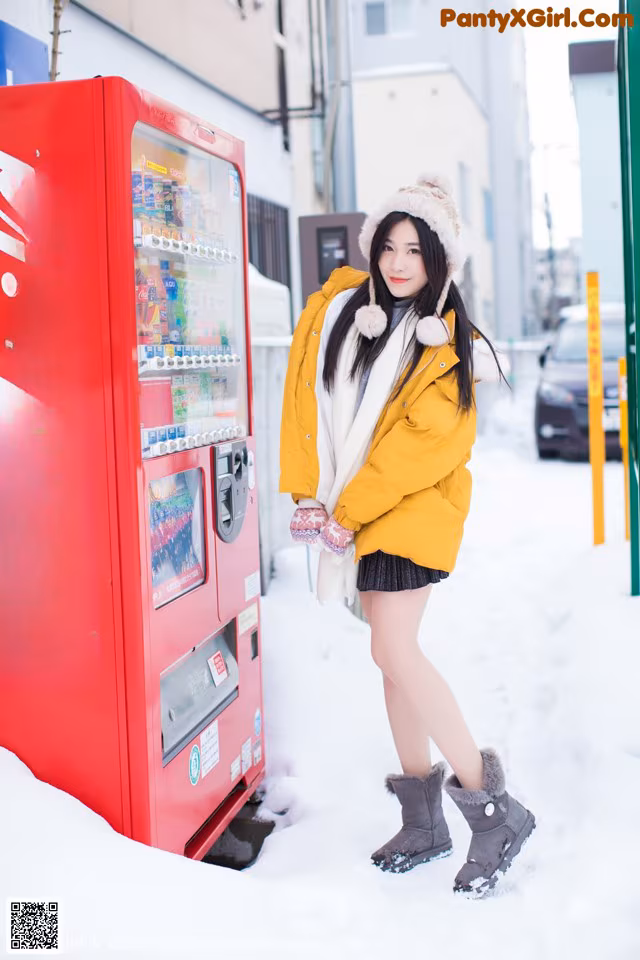 A woman standing in front of a coca cola vending machine.