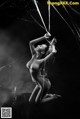 A naked woman is hanging from a spider web.