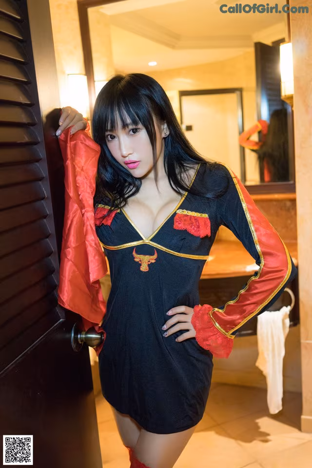 A woman in a black and red dress posing for a picture.