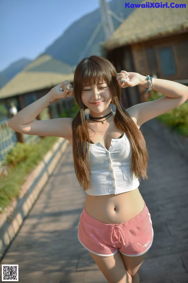 A woman in pink shorts and a white shirt posing for a picture.