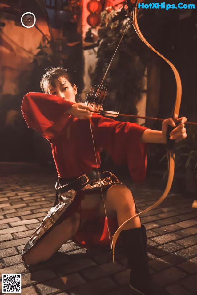A woman in a red dress holding a bow and arrow.