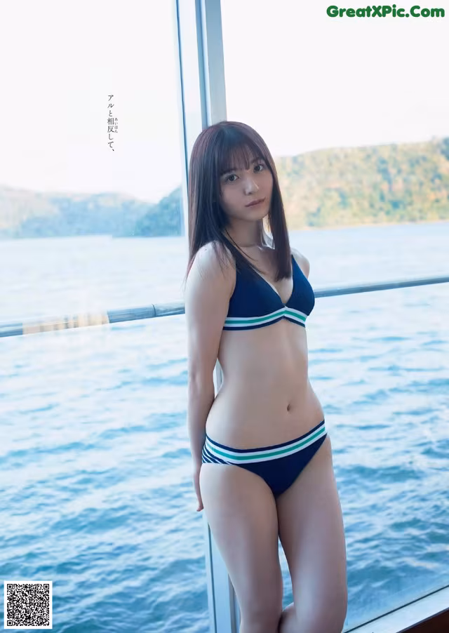 A woman in a bikini standing on a boat.