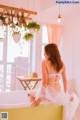 A woman sitting in a bathtub in a white lingerie.